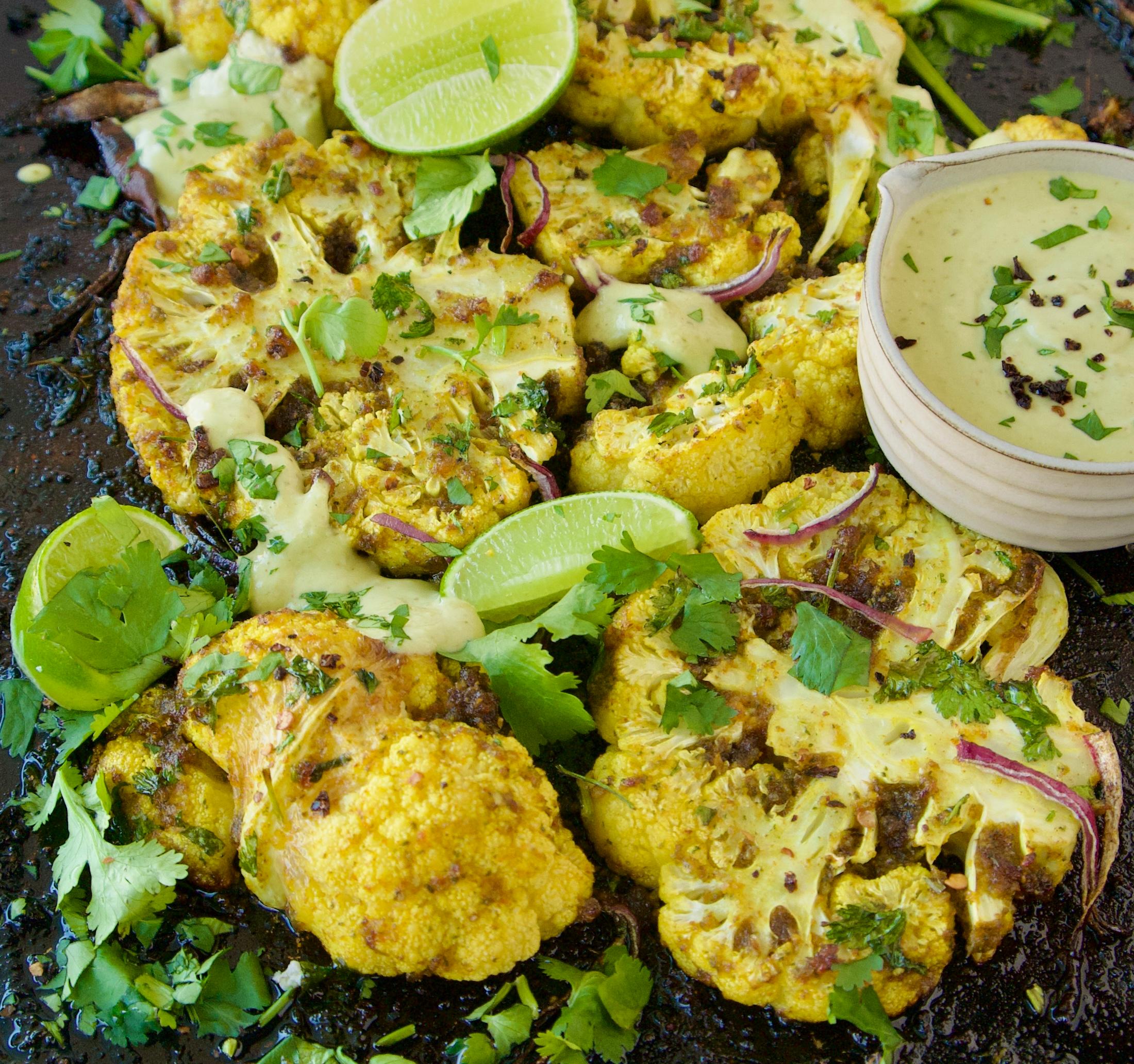 Finished Chipotle Lime Cauliflower Steaks with Avocado Crema topped with pepitas and cilantro