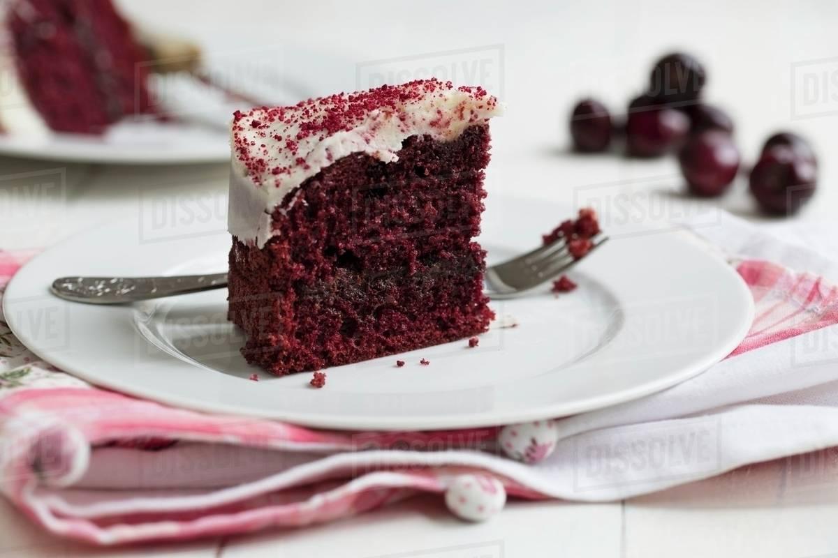 a slice of red velvet cake on a plate with a fork