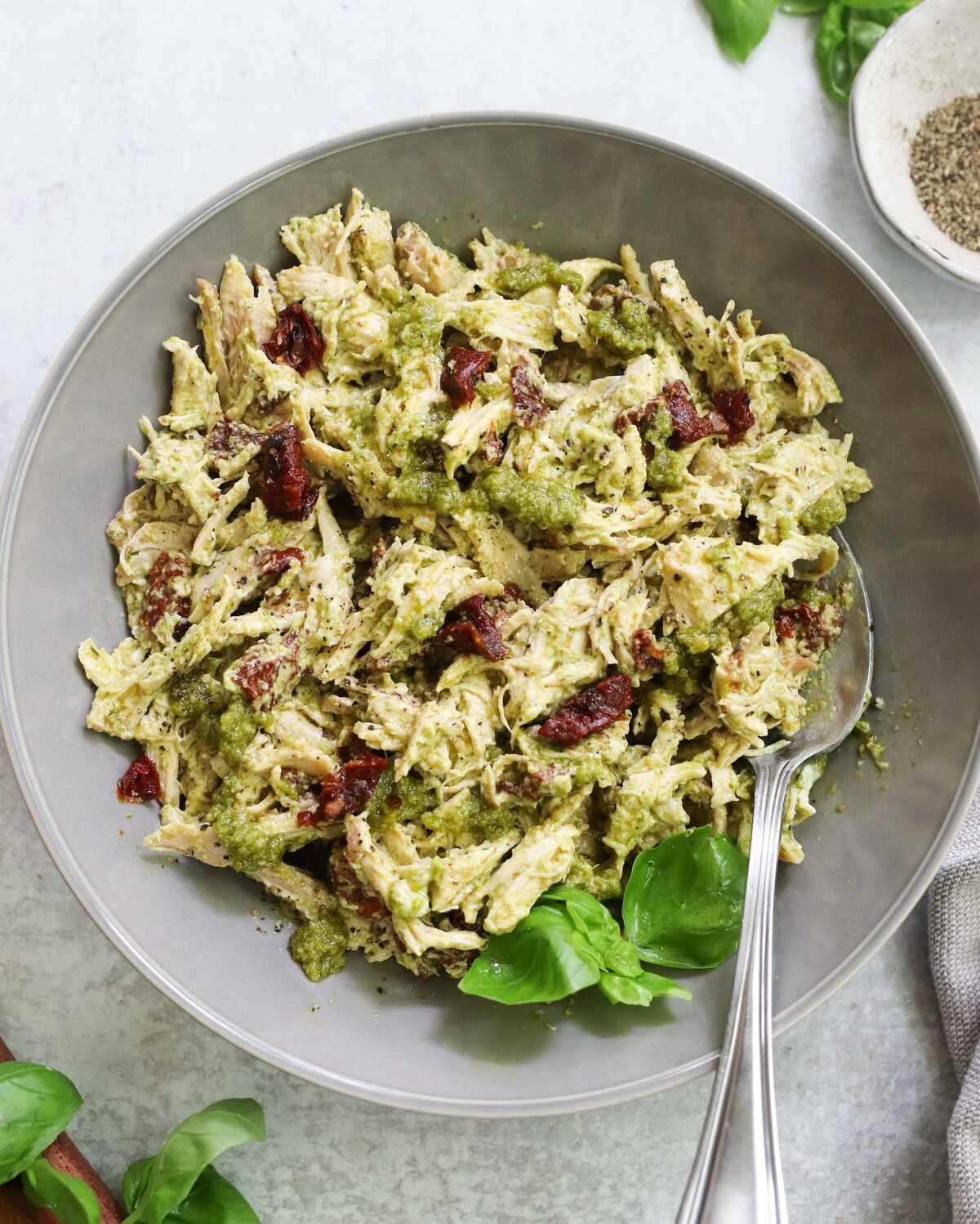 pesto chicken salad with sun-dried tomatoes in a bowl