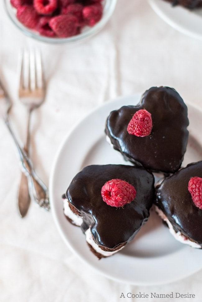 woman happily taking a bite of chocolate raspberry mini cake