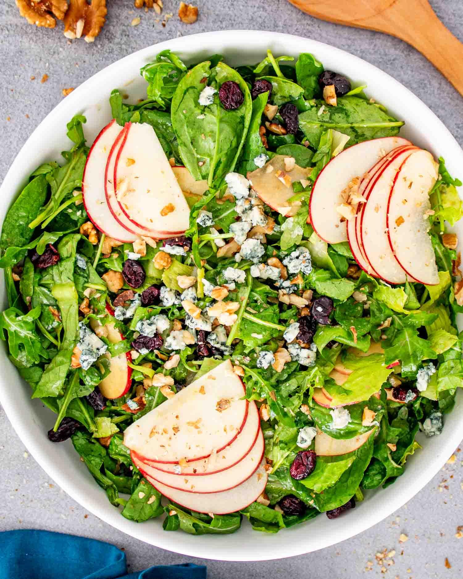Person enjoying a fresh apple walnut salad outdoors, vibrant colors