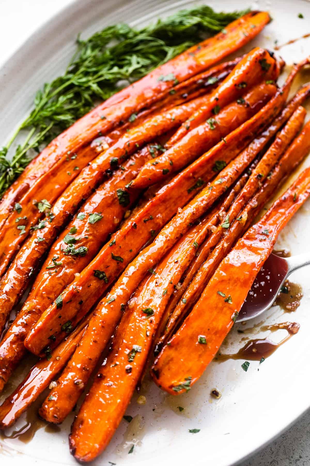 close up of carrot fries being drizzled with balsamic glaze