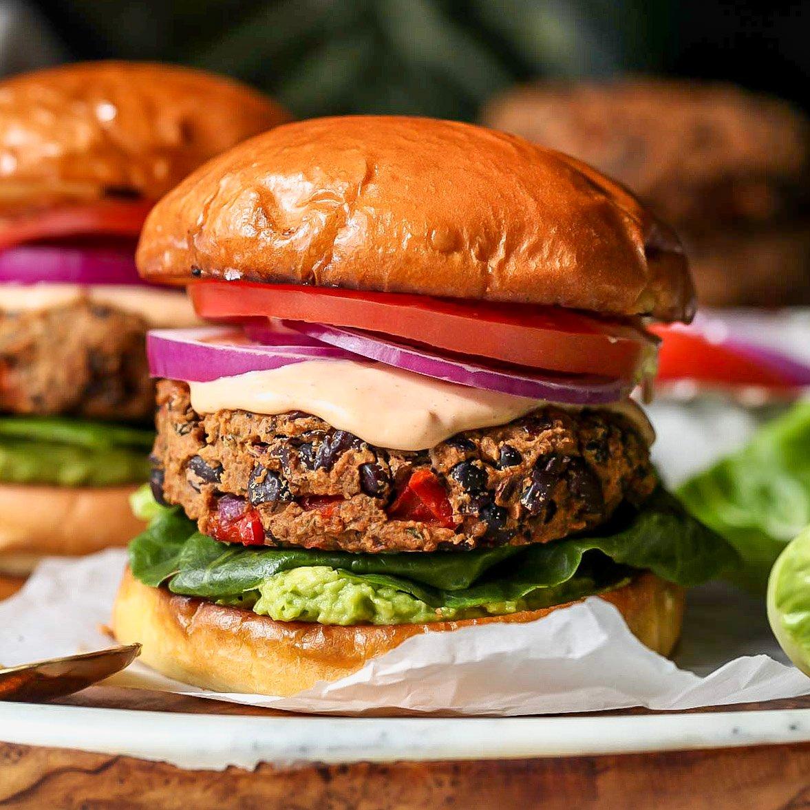 black bean burger being assembled with toppings