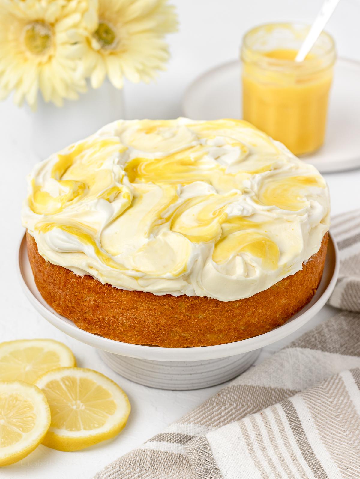 Close-up of a beautifully sliced lemon yogurt cake on a white plate with a lemon slice garnish