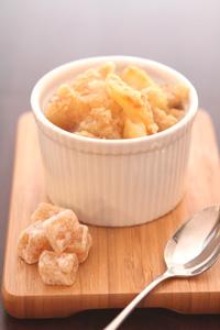 close up of a slice of apple crisp with elderflower syrup on a plate, steam rising