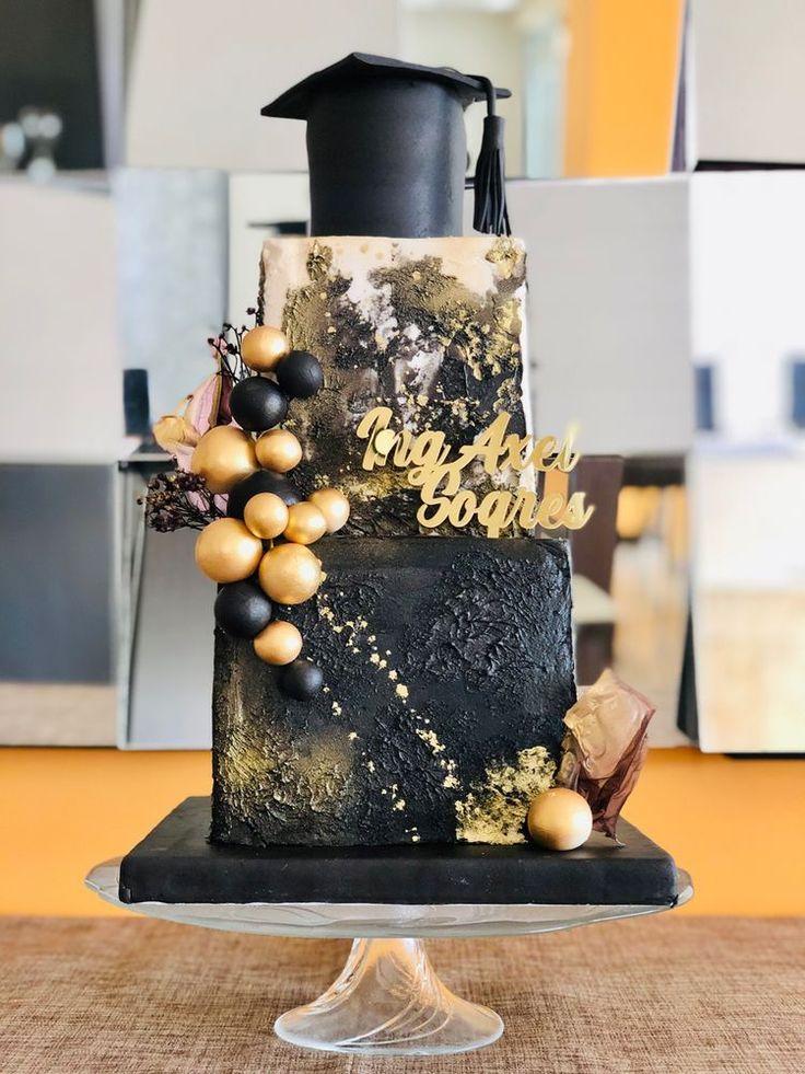 a beautifully decorated layer cake with graduation cap and diploma decorations on a celebratory table
