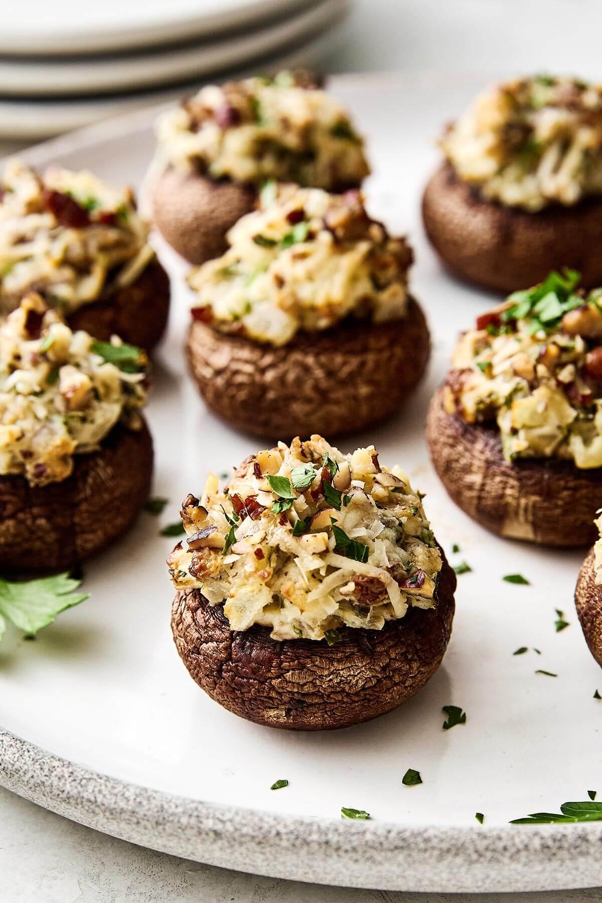 Platter of golden brown stuffed mushrooms at a holiday party