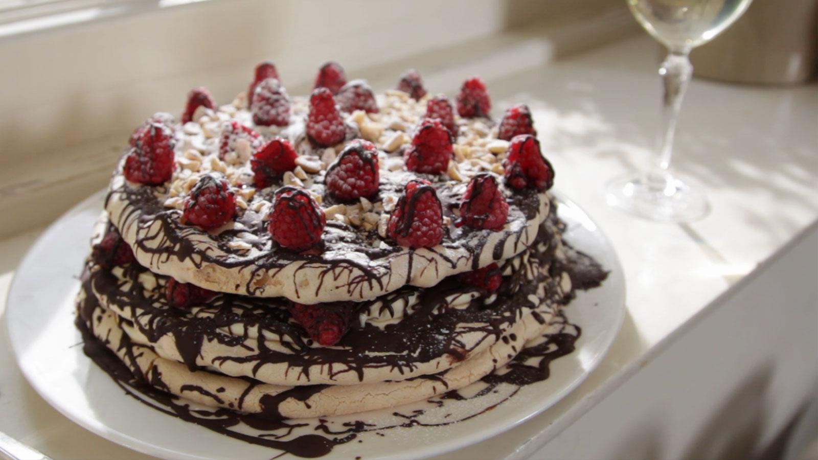 Overhead shot of a partially assembled chocolate vacherin, showing the meringue layers and cream