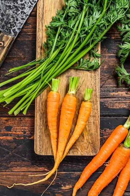 fresh carrots on a wooden cutting board