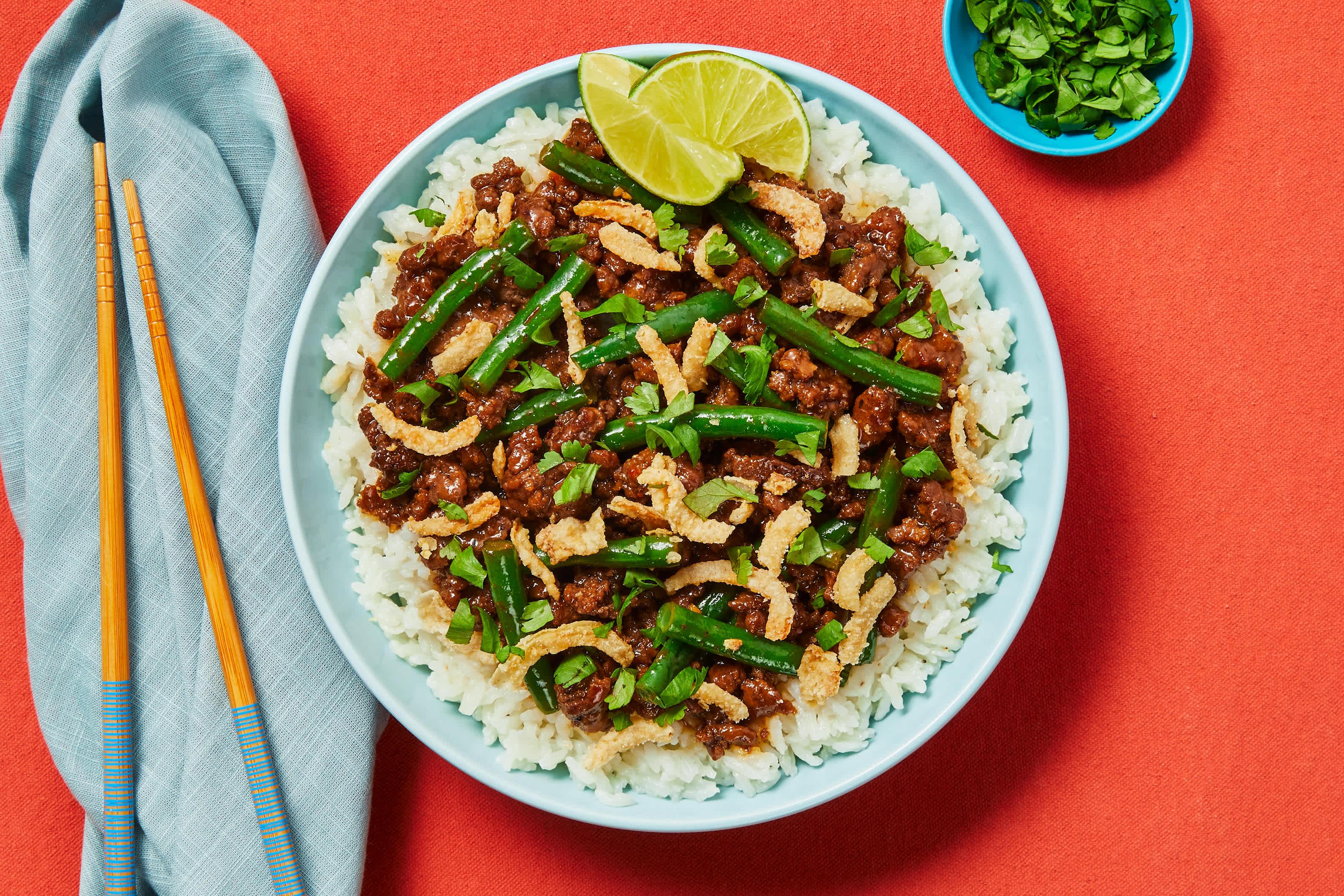 beef and green bean bowl with various topping options
