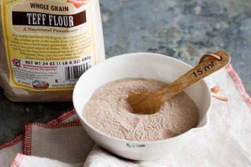 Teff flour being measured into a mixing bowl.