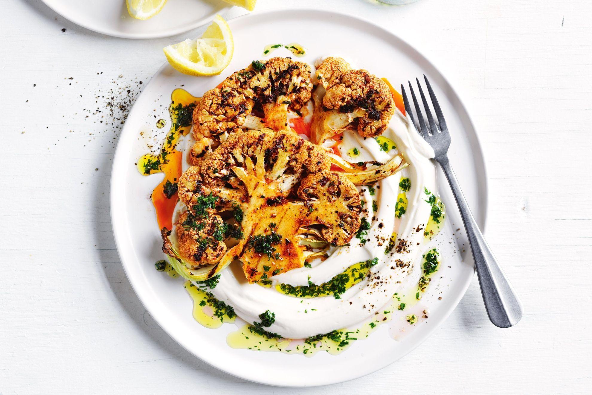 Smoked paprika being sprinkled on a cauliflower steak.
