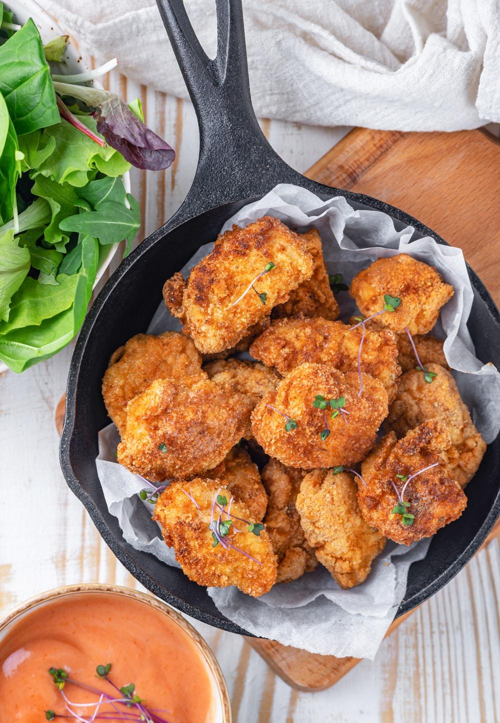 crispy keto chicken nuggets with almond flour on a wooden board