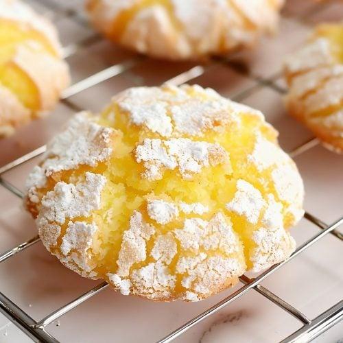 bright yellow lemon cookies dusted with powdered sugar on a cooling rack, vibrant light