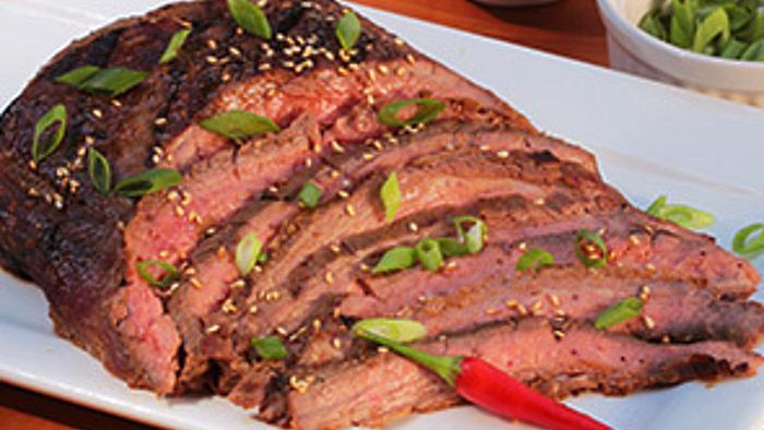 grilled korean bbq flank steak sliced and plated with side dishes