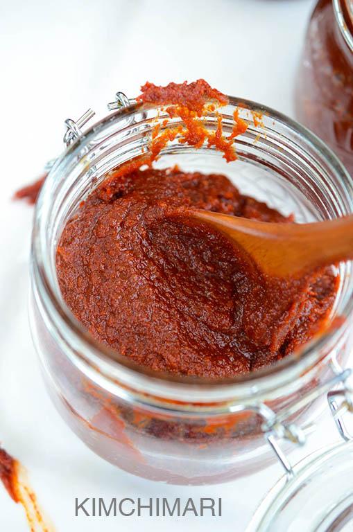 Close-up shot of Gochujang paste being scooped from a jar