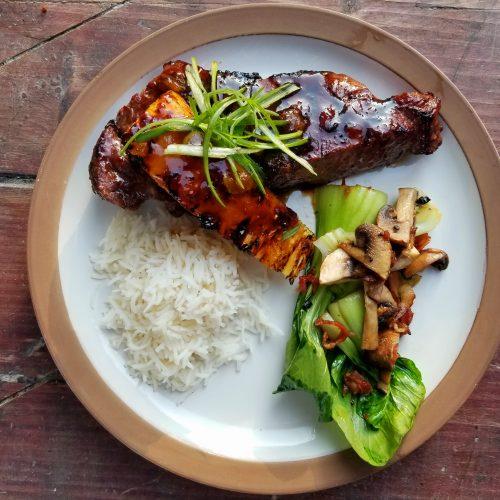 steak with teriyaki sauce being grilled outdoors