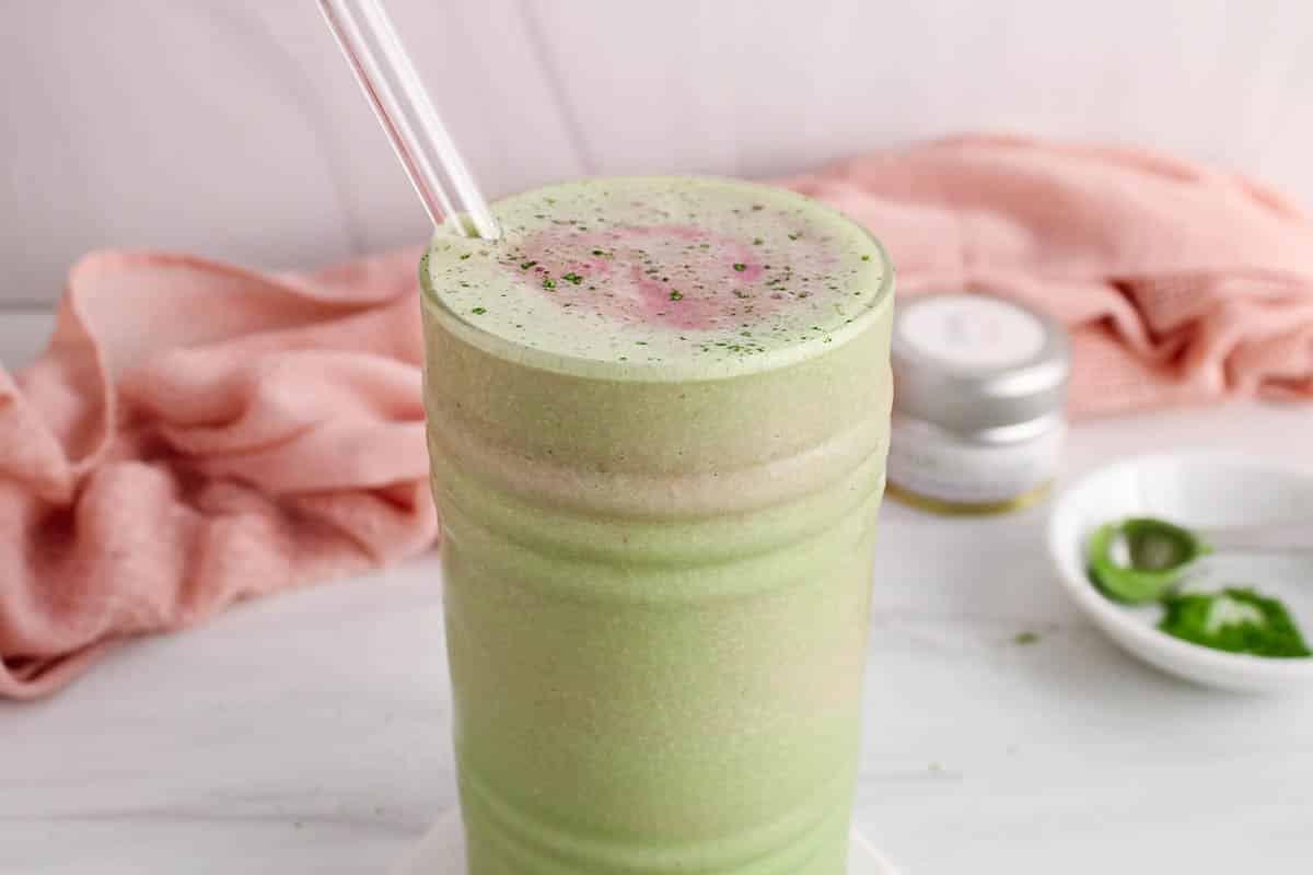 a blender filled with ingredients for a matcha smoothie, mid-blend