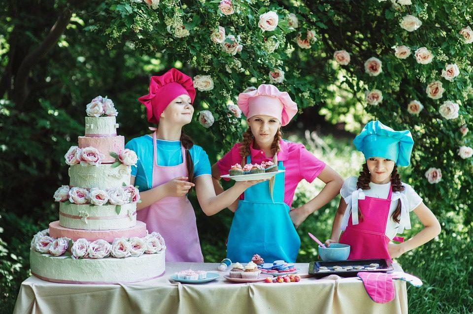 A baker smiling while decorating a colorful cake