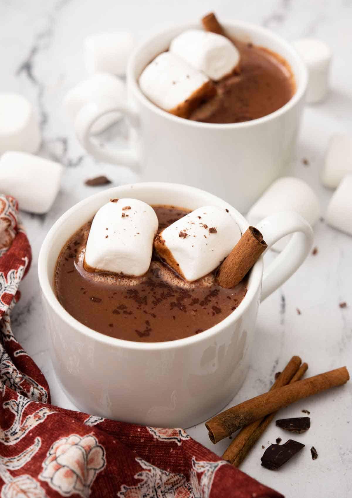 Mexican hot chocolate with cinnamon sticks and chili flakes, cozy setting