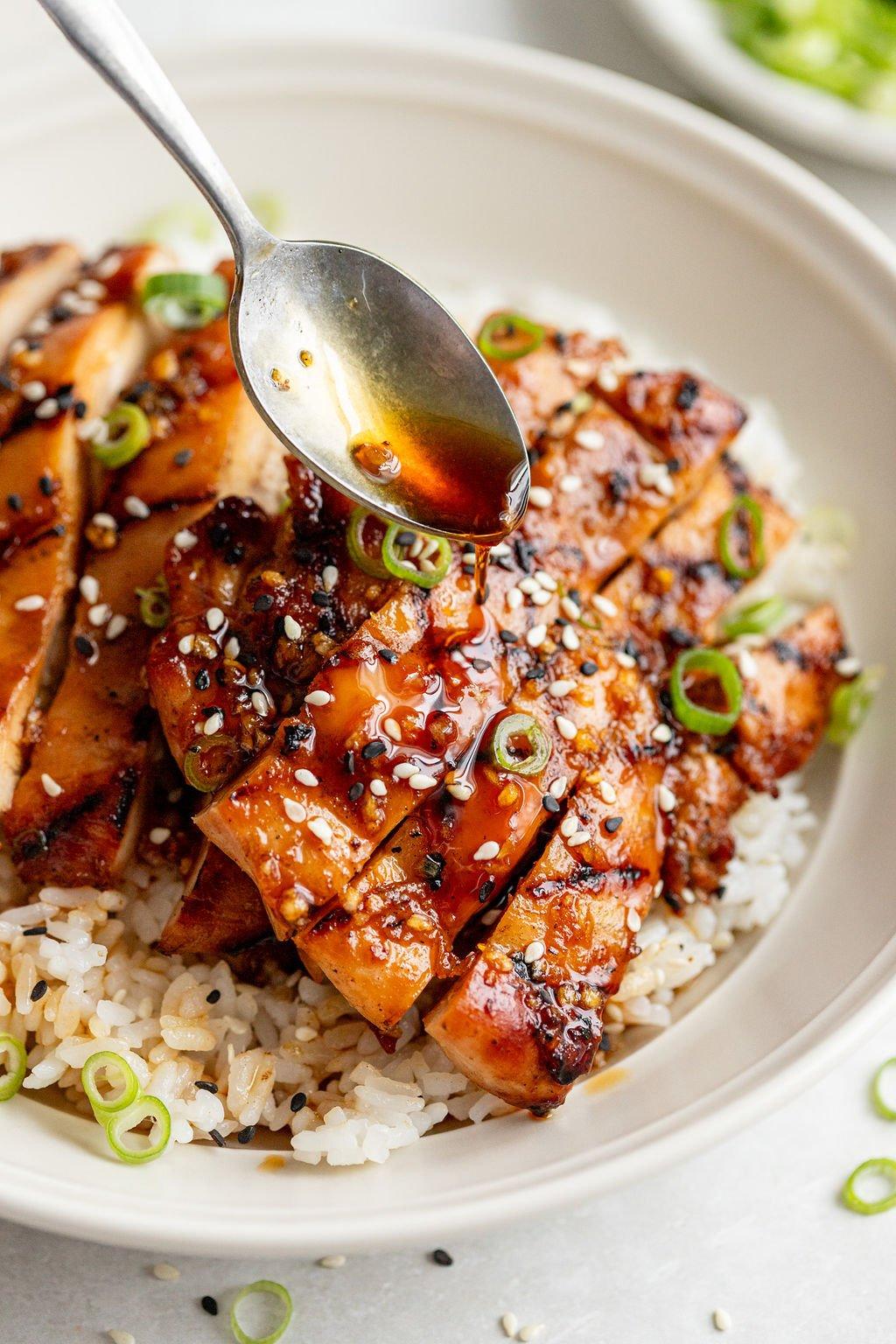 close up shot of grilled chicken marinating in a bowl
