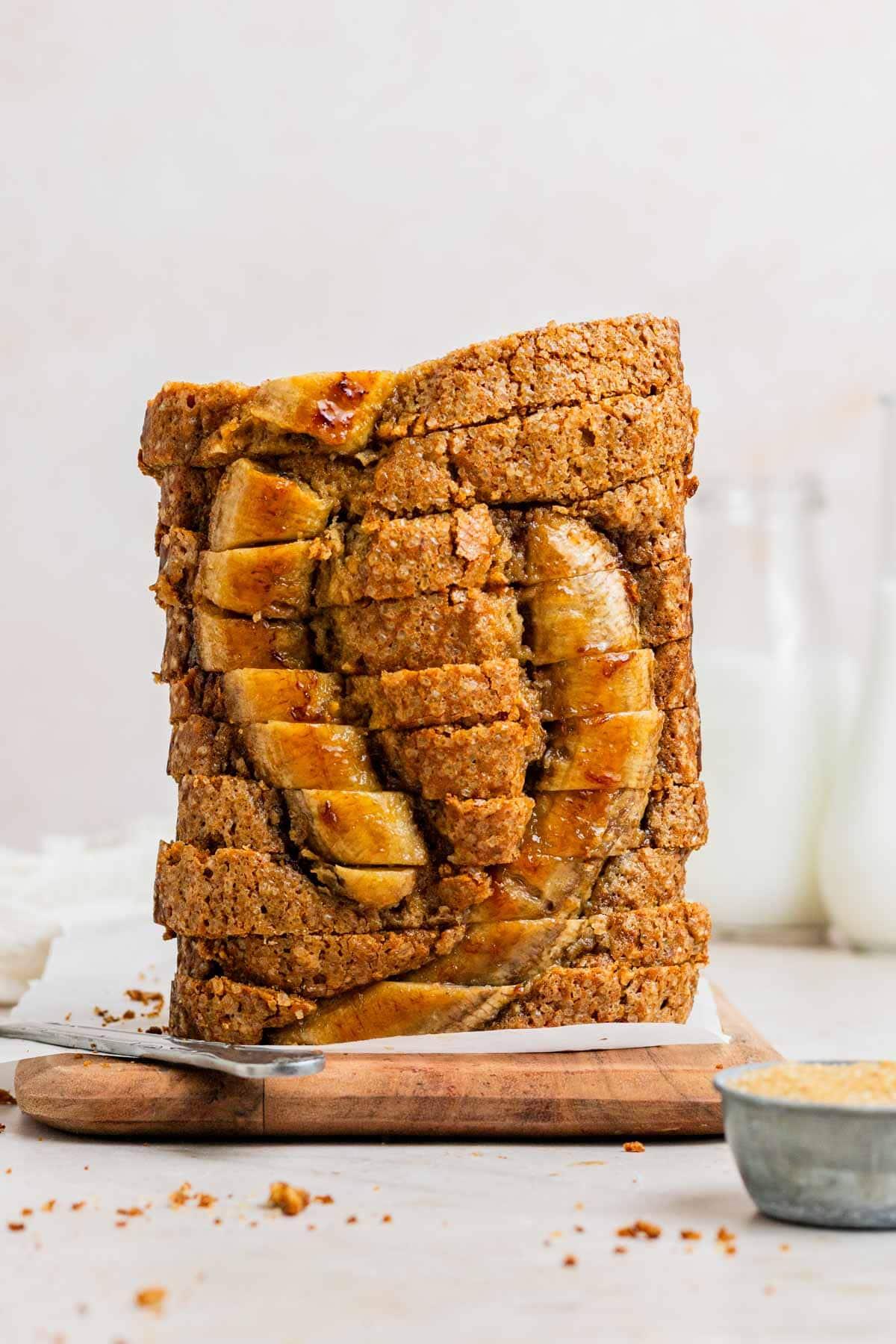 Warm slice of caramel banana ripple bread on a rustic wooden board with a cup of coffee