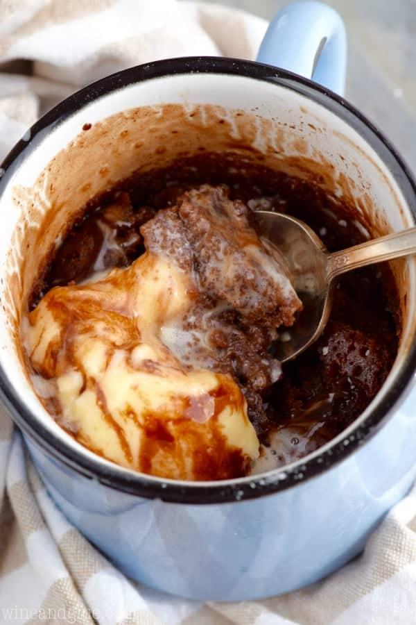 salted caramel swirl mug cake with a spoon scooping out a bite