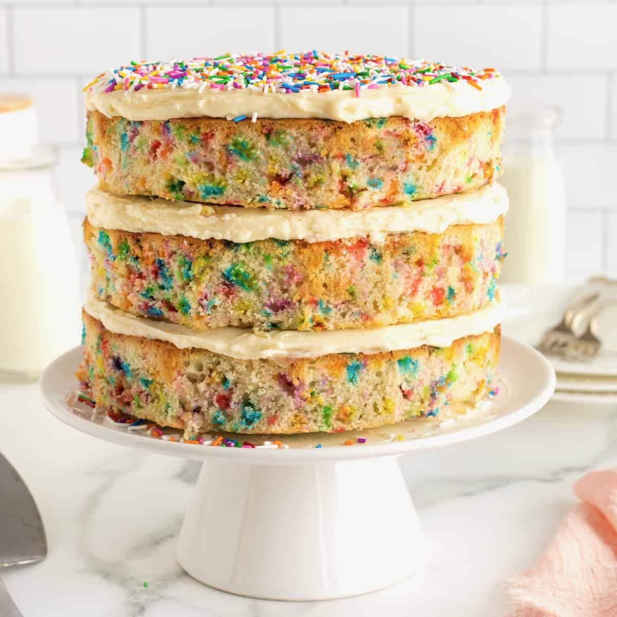 colorful confetti vanilla layer cake on a cake stand