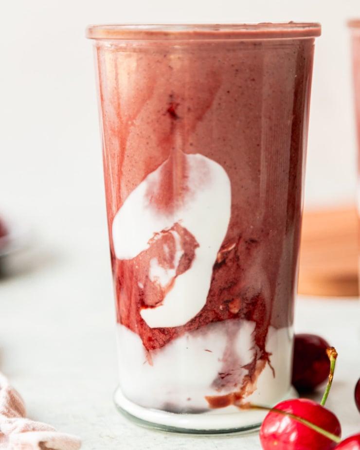 close-up shot of a glass filled with cherry chocolate protein smoothie