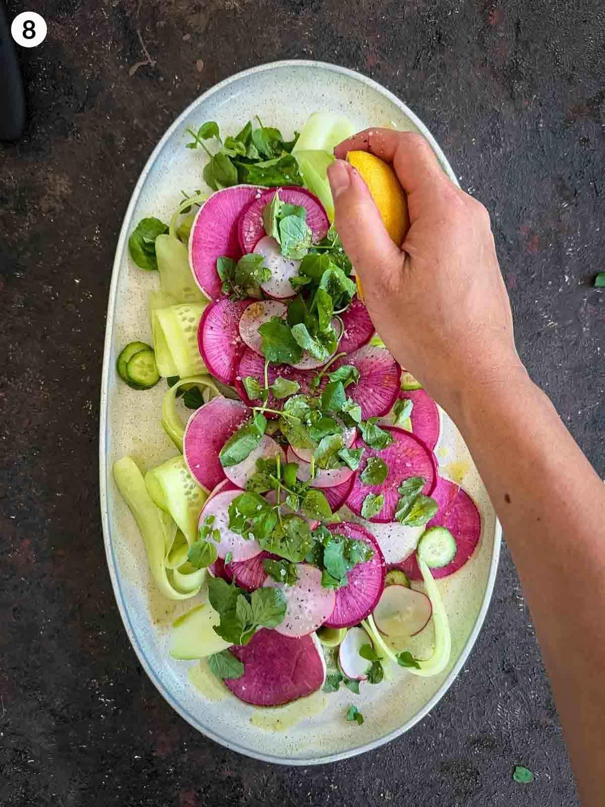 Spicy watermelon radish rocket salad being tossed in a bowl