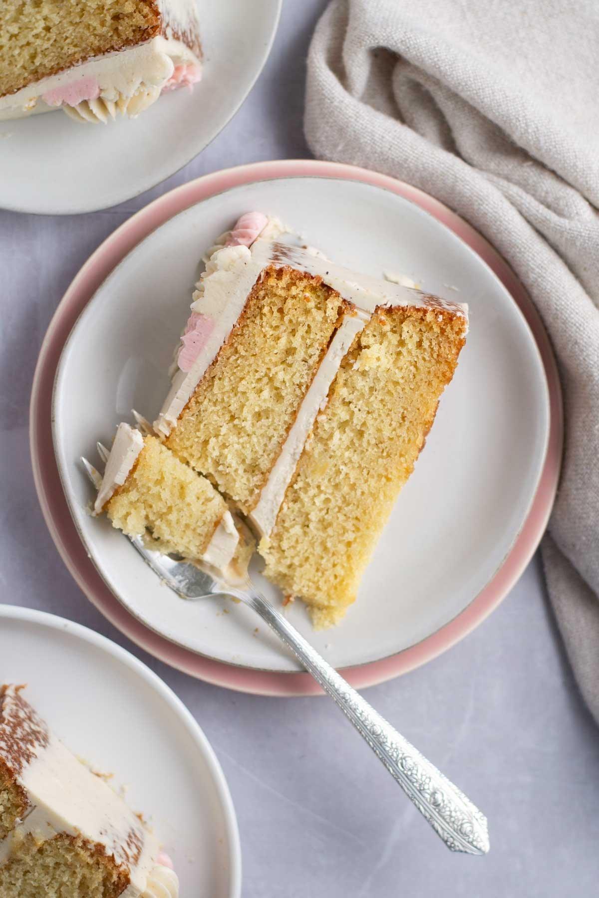 Close-up shot of a slice of vanilla bean cake showing the moist crumb and vanilla bean specks