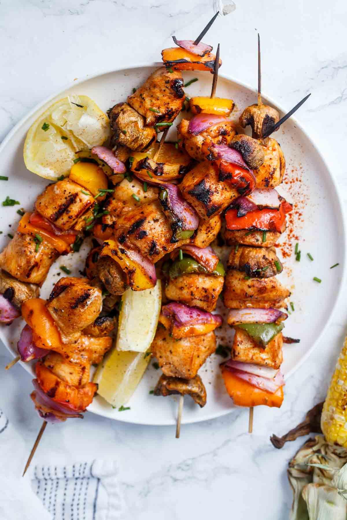 close up of finished chicken and vegetable skewers on a plate