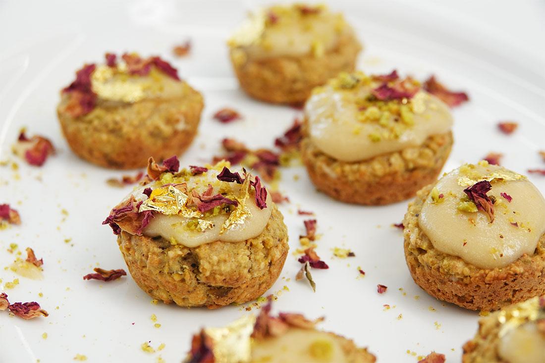 hands decorating saffron cardamom cake pops with edible glitter and crushed pistachios