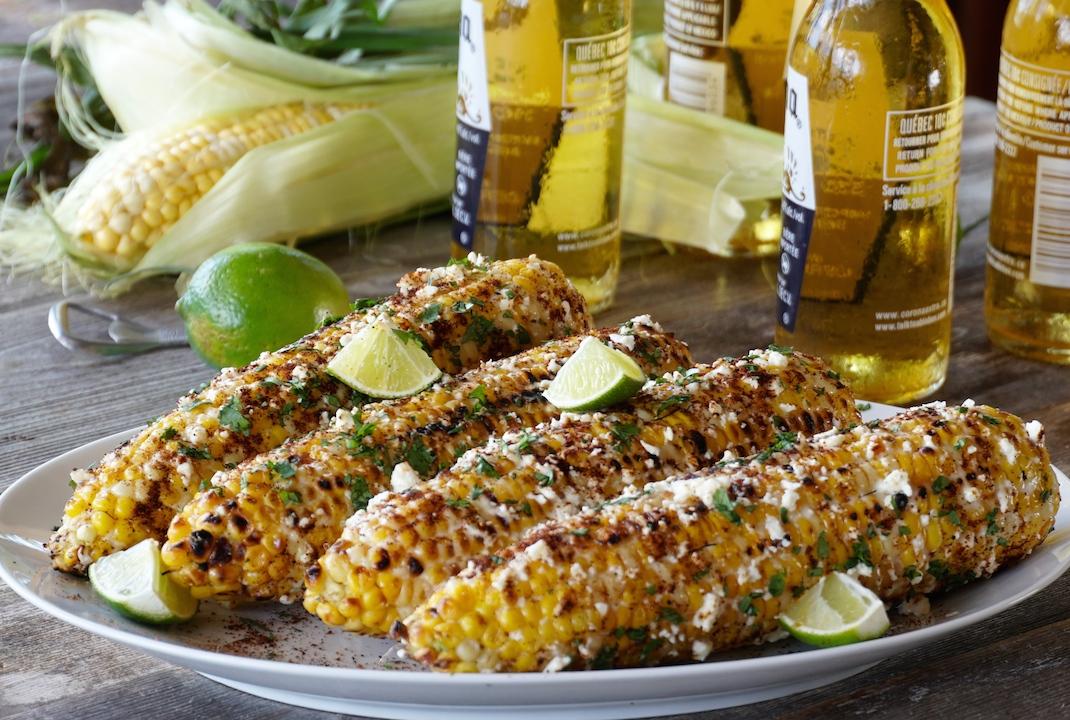 Poblano & Queso Oaxaca Elote being served at an outdoor cookout