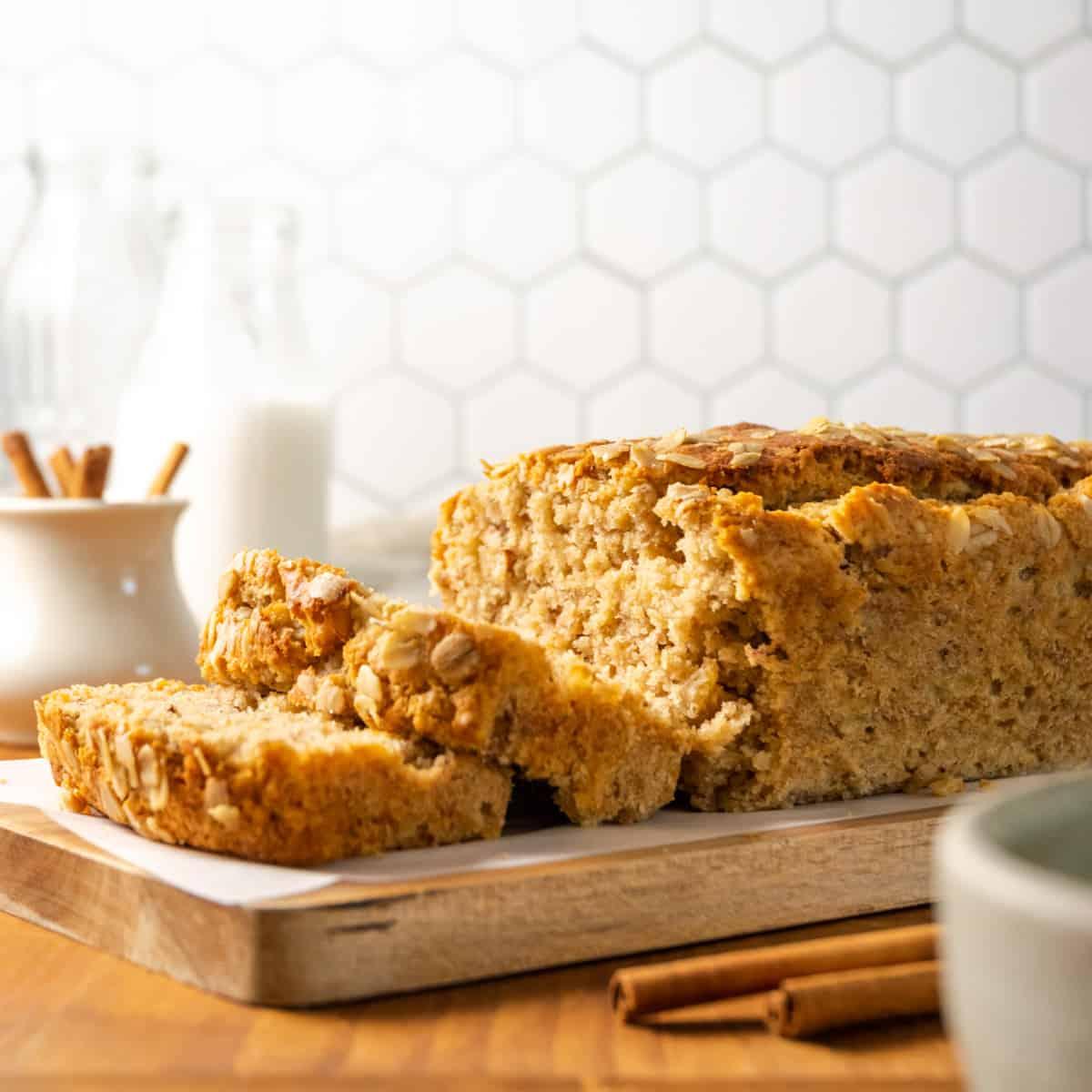 gluten-free banana bread with maple glaze on a wooden cutting board