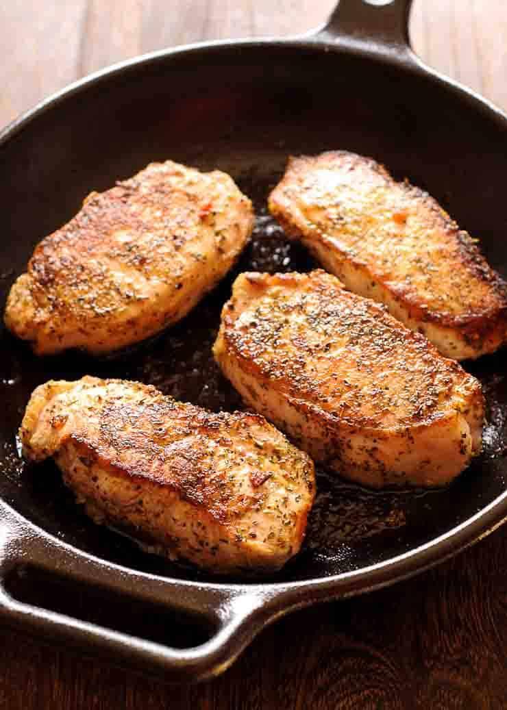 pork chops searing in a hot skillet