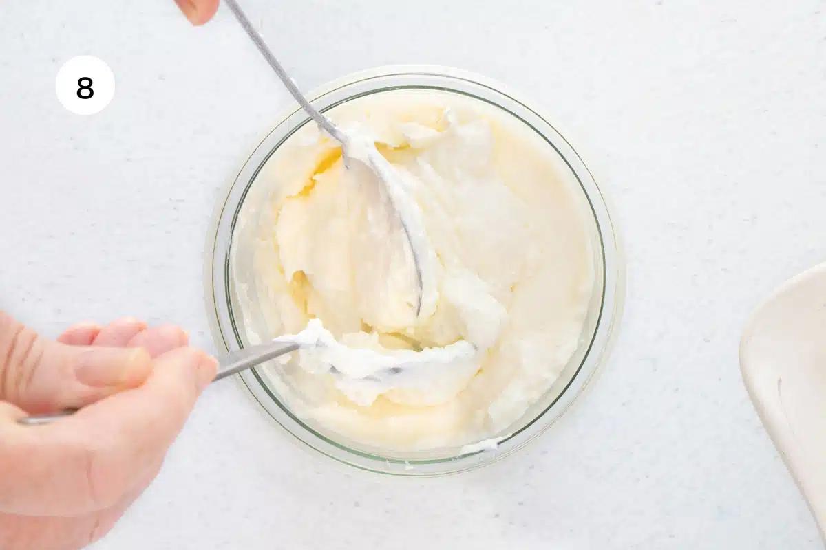 creamy greek yogurt being spooned into a glass
