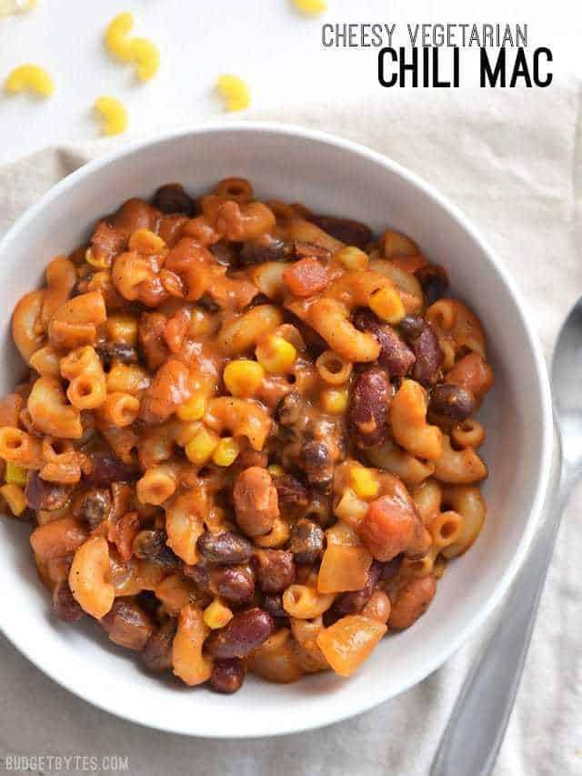 serving spoon scooping vegetarian chili mac and cheese from a casserole dish