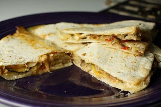 a person assembling ratatouille quesadillas