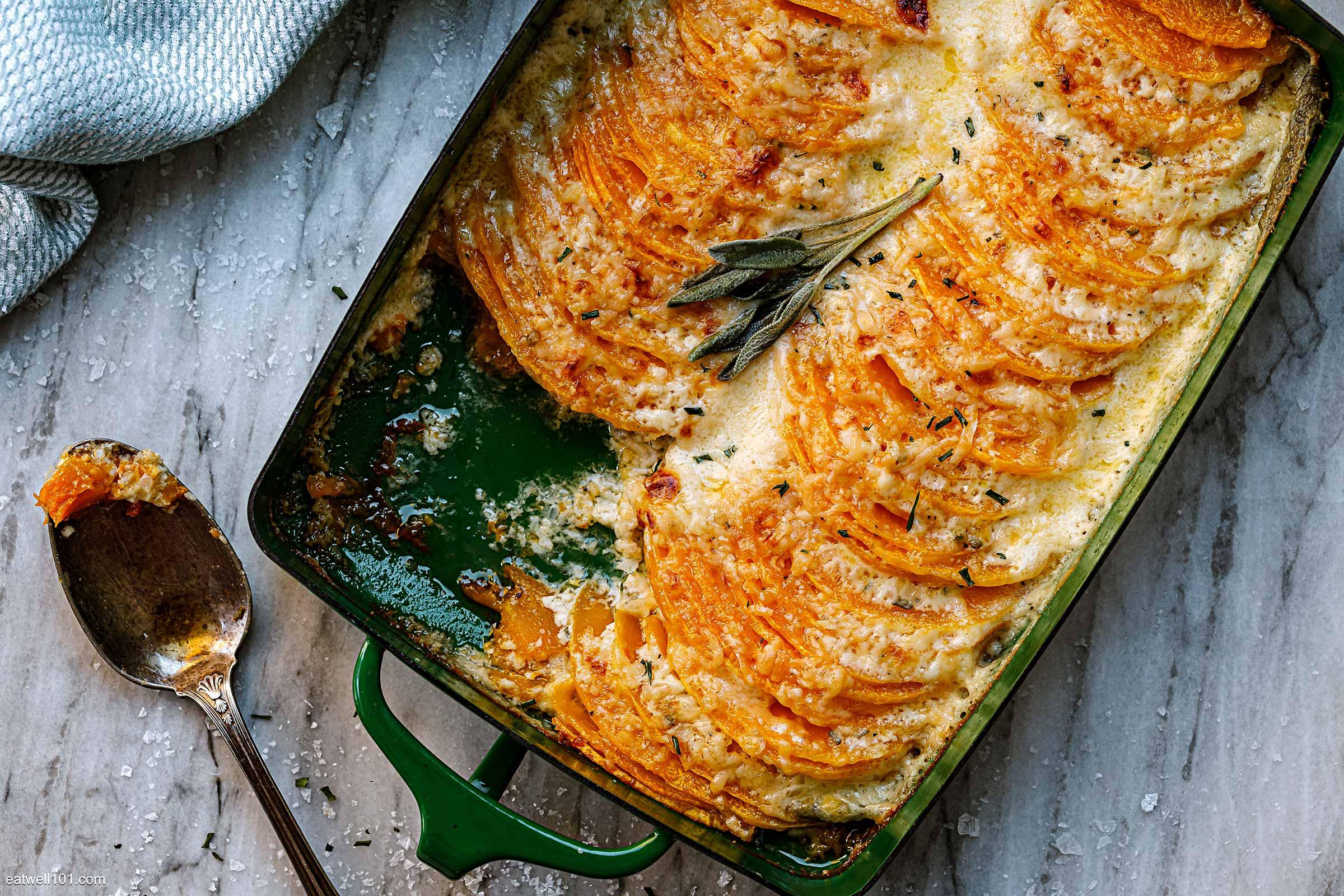 Close-up of golden brown maple butternut squash gratin with fresh sage garnish