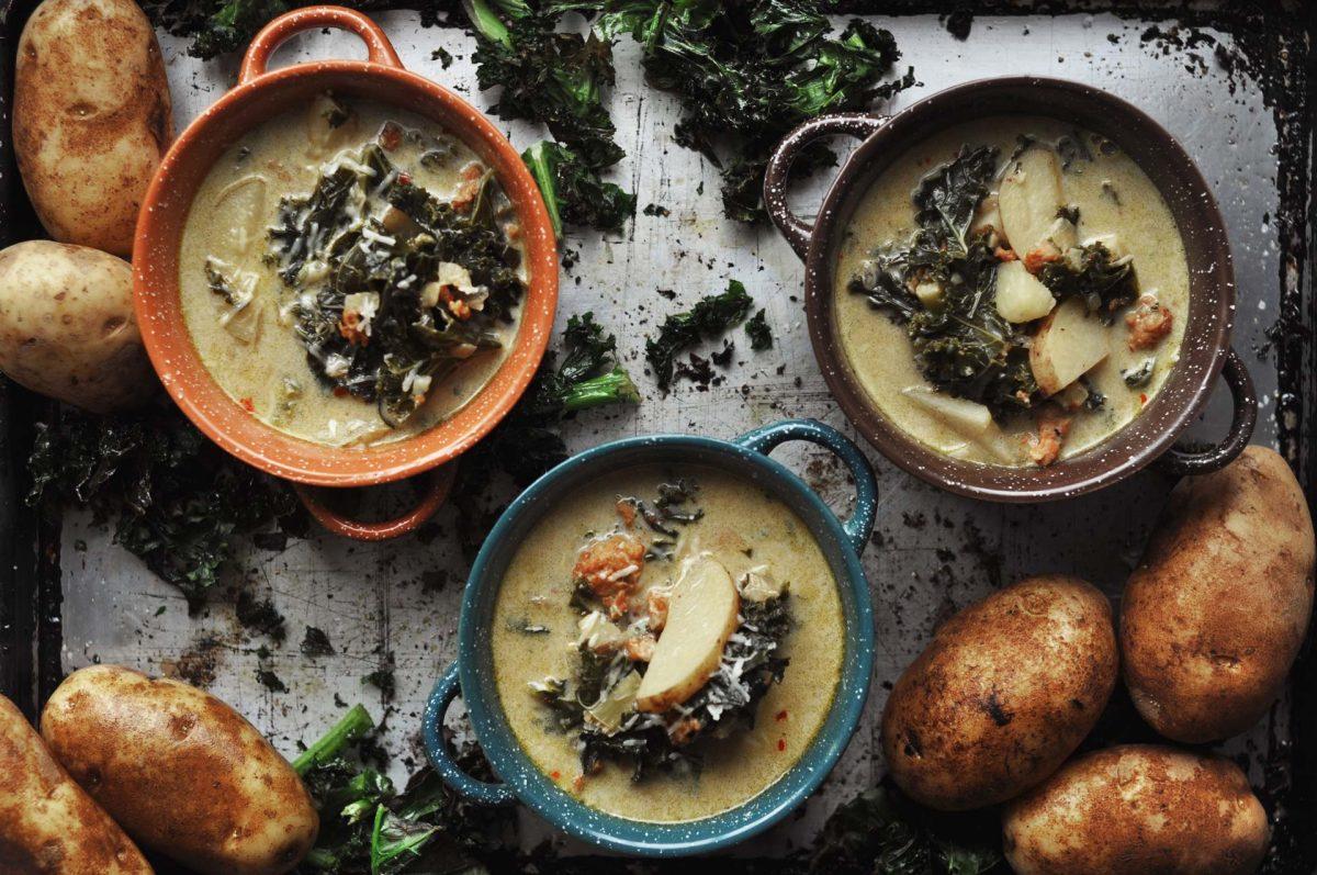 close up of spicy sausage kale and potato soup in a rustic bowl