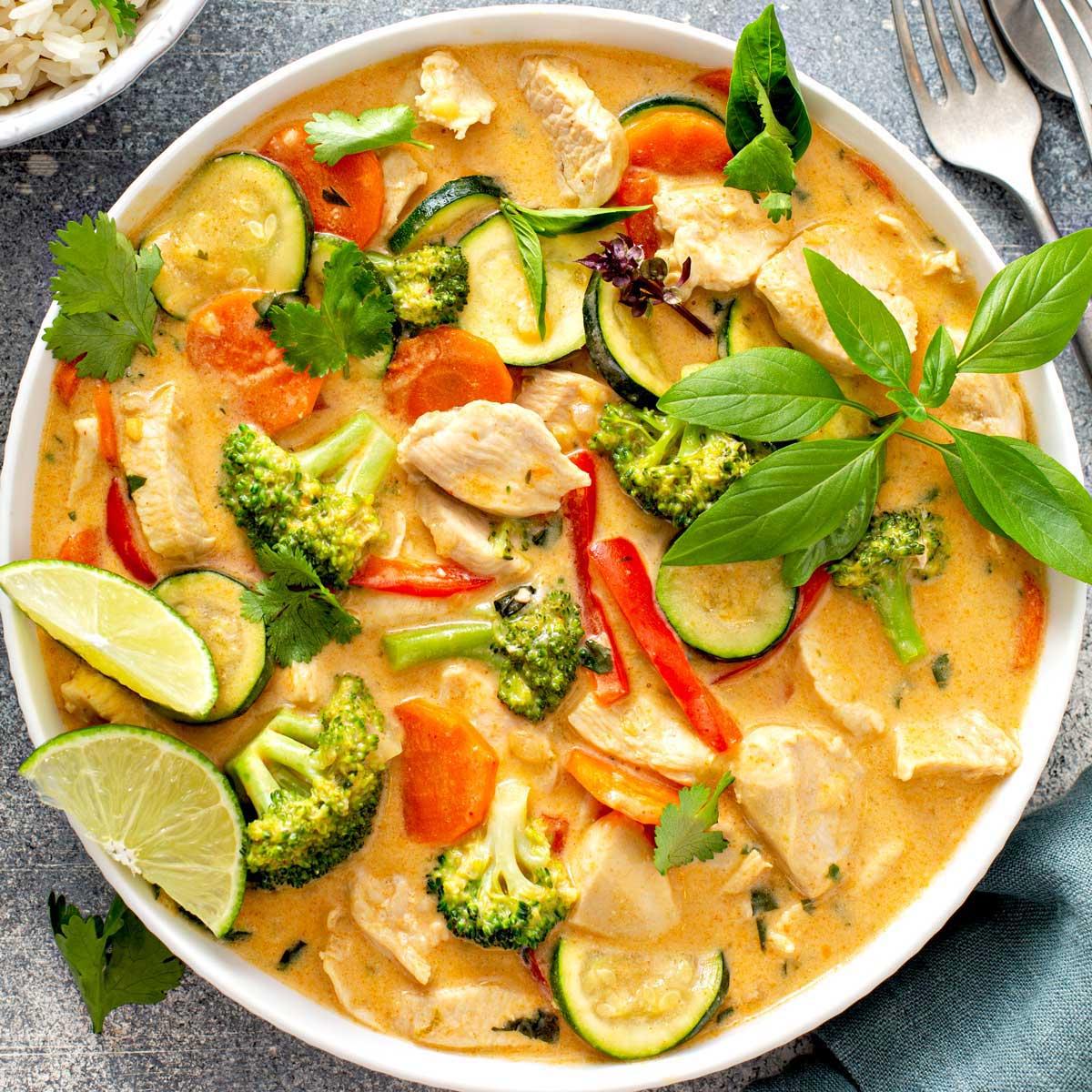 a person dipping a coconut curry lime carrot fry into a flavorful sauce