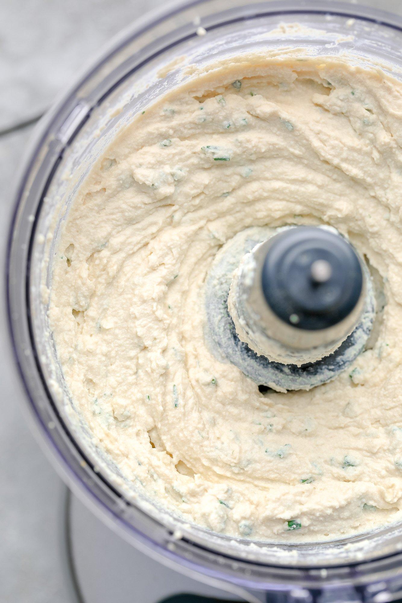 close up of tofu being blended in a food processor