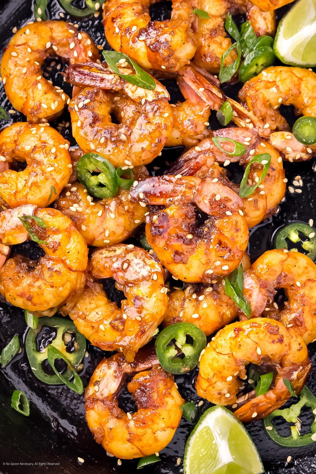 close-up shot of a single perfectly glazed honey garlic shrimp, glistening, with a hint of steam
