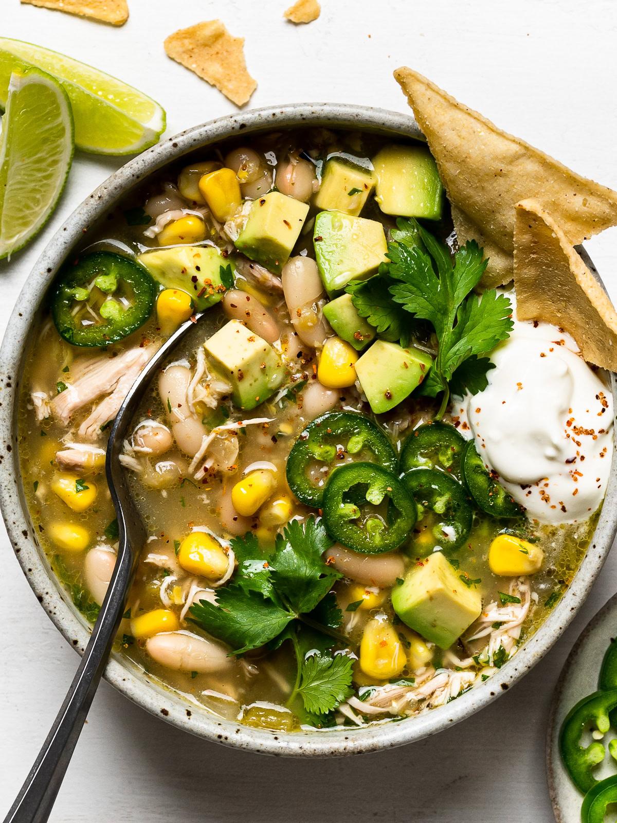 white chicken chili served in bowls with toppings