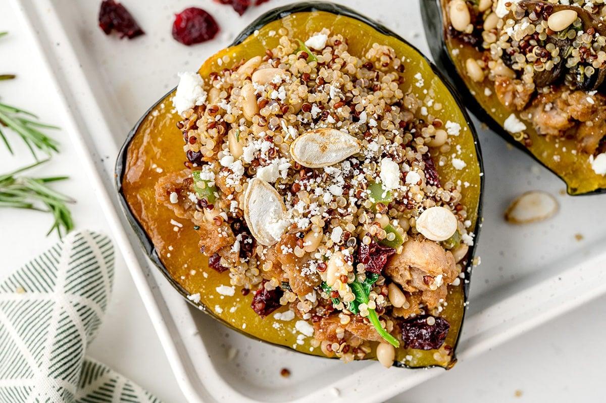 Close-up shot of the finished Chicken Quinoa Stuffed Acorn Squash, garnished with fresh herbs