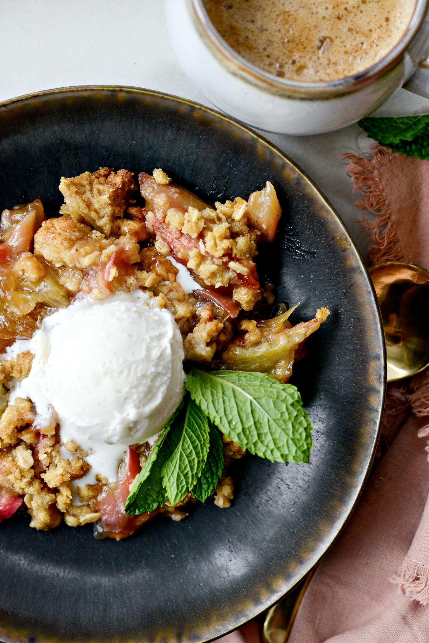 A bowl of toasted sesame seeds next to a sliced rhubarb crumble