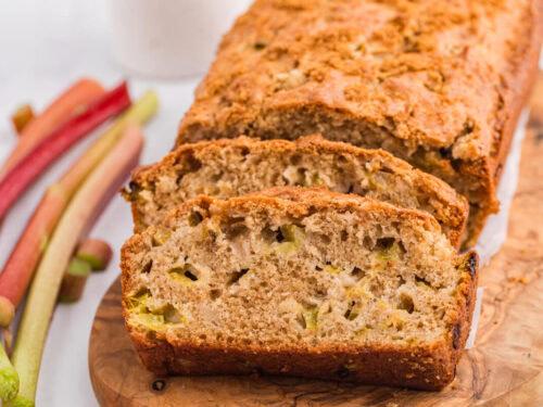 Freshly baked rhubarb and macadamia bread on a wooden cutting board, rustic kitchen setting