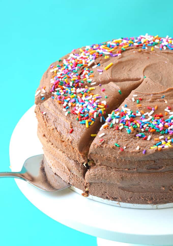 hands frosting a vanilla cake with nutella frosting