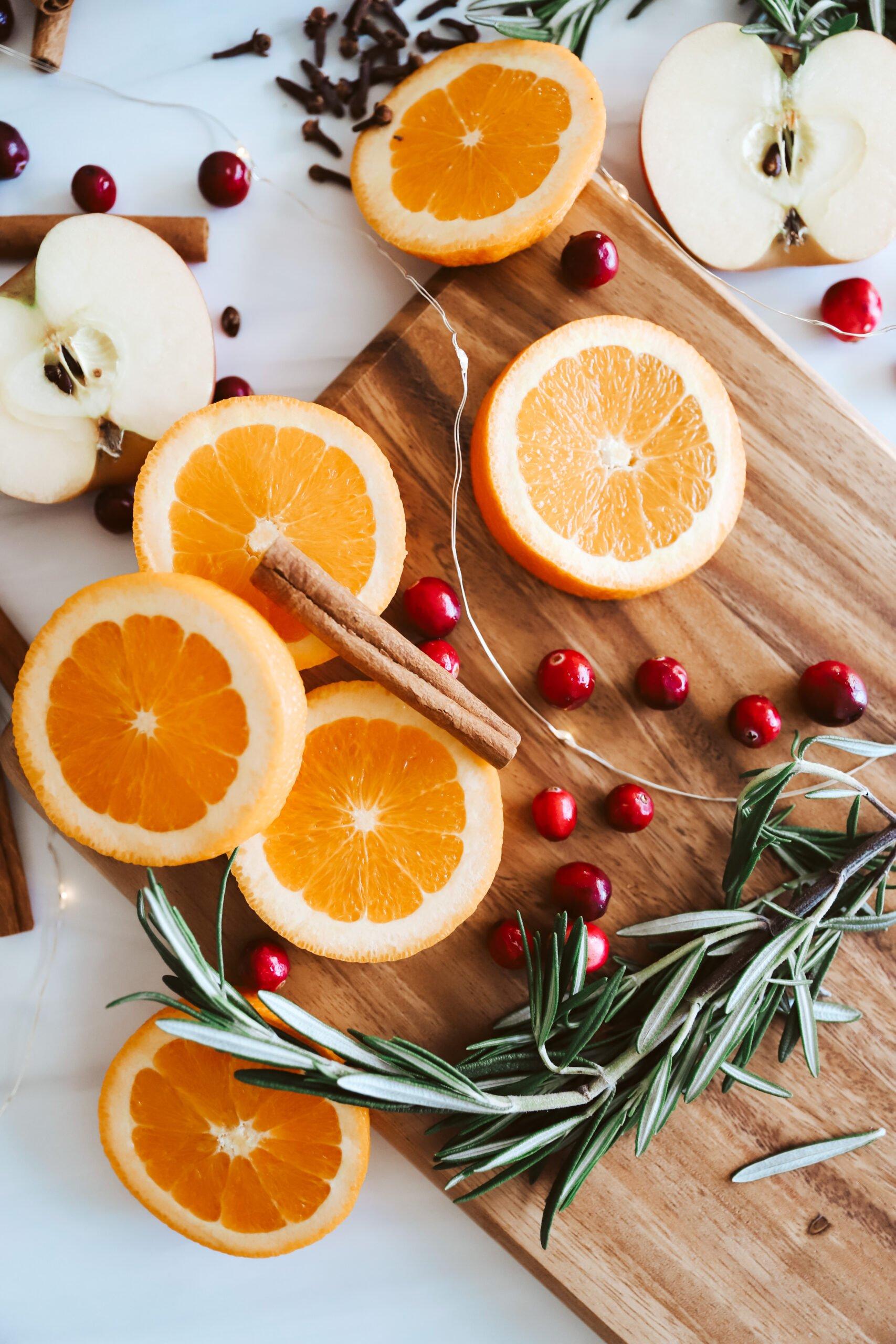 fresh cranberries and oranges sliced on a cutting board